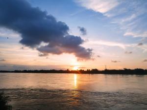 a sunset over a river with the sun setting at Happy Pelangi Homestay Kota Bharu 4 Room Penthouse in Kota Bharu