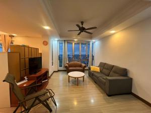 a living room with a couch and a ceiling fan at Happy Pelangi Homestay Kota Bharu 4 Room Penthouse in Kota Bharu