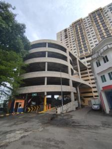 a large building in front of two tall buildings at Happy Pelangi Homestay Kota Bharu 4 Room Penthouse in Kota Bharu +15 photos