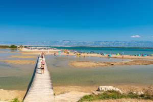 a pier on a beach with a crowd of people at Apartments with a parking space Nin, Zadar - 23493 in Nin