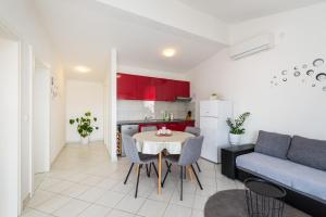a kitchen and a living room with a table and a couch at Apartments with a parking space Nin, Zadar - 23493 in Nin