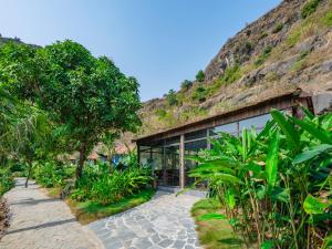 dom z trawiastym wzgórzem za nim w obiekcie Trang An Mountain Resort w mieście Ninh Binh