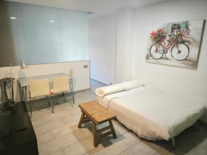 a bedroom with a bed and a table with a bike on the wall at Olof Apartment in Las Palmas de Gran Canaria