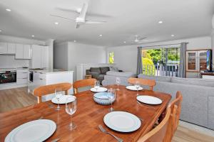 a dining room and living room with a table and chairs at Gidget's Getaway in Nelson Bay
