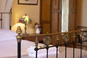 a bedroom with a bed and a table with a lamp at Rose Petal Cottage Quaint Studio In Ballarat in Ballarat