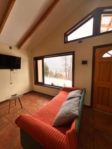 a bedroom with a bed and a large window at Cabañas Altos del Sollipulli in Rumiñano