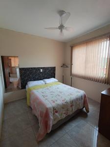 a bedroom with a bed and a window at pousada Montanhez ap3 in Caparaó Velho