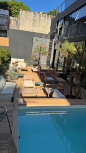 a swimming pool with lounge chairs and a building at Fit 26 26 de marzo 3330 in Montevideo