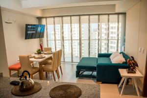 a living room with a blue couch and a table at Lindo Apartamento en rodadero sur in Gaira