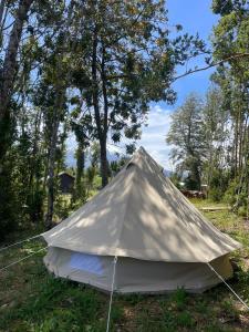 a canvas tent in the middle of a field at Glamping peumayen in Puerto Varas