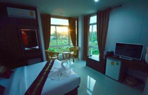 a hotel room with a bed and a television at หมื่นช้างน่านบูทีคHotel in Nan
