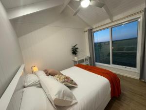 a bedroom with a large bed and a window at Kingdom Cottages in Gulgong