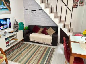 a living room with a couch and a staircase at Casa de praia de Ibicuí - RJ in Mangaratiba