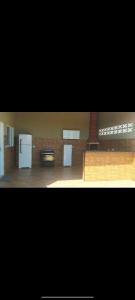 cocina con electrodomésticos blancos y pared de ladrillo en Rancho Santana, en Presidente Epitácio