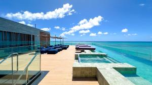 a swimming pool with a view of the ocean at Edifício New Time Apto 1016 Pajuçara Maceió AL in Maceió