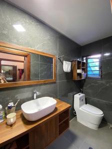 ein Badezimmer mit Waschbecken, Toilette und Spiegel in der Unterkunft Rose Villa Thai Nguyen - Venuestay in Thượng Nhân