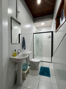 a bathroom with a toilet and a sink and a shower at Suite Familia B2 in Pomerode +11 photos