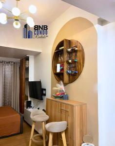 a living room with two stools and a mirror at Studio2 - BNB Condo Rentals CDO in Lapasan