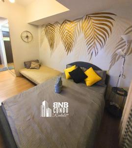 a bedroom with a bed with yellow and black pillows at Studio2 - BNB Condo Rentals CDO in Lapasan