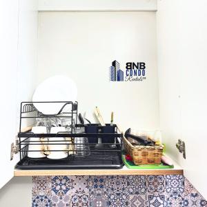 a kitchen shelf with dishes and a basket on it at Studio2 - BNB Condo Rentals CDO in Lapasan