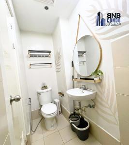 a bathroom with a toilet and a sink and a mirror at Studio2 - BNB Condo Rentals CDO in Lapasan