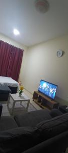 a living room with a couch and a flat screen tv at Furnished daily studio basis in Dubai