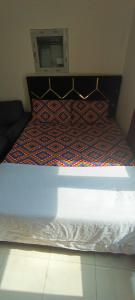 a bedroom with a bed with a blue bedspread at Furnished daily studio basis in Dubai