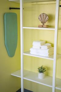 une étagère blanche avec des serviettes et une plante dans l'établissement Waikiki Seaside Monarch Paradise Hotel Studio Near Waikiki - Mountain and City View - Full Kitchen, à Honolulu