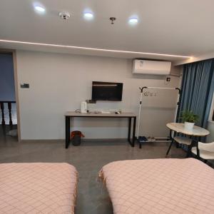 a room with two beds and a tv and a table at Wangxian Valley Qingchuanxingguan - Wangxian Valley Scenic Area in Jiangcun