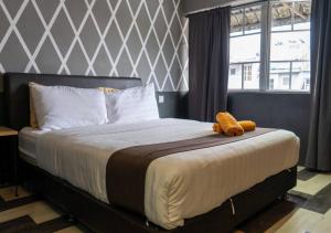 a bed with a stuffed animal sitting on top of it at Kavy Boutique Hotel @ KBH in Brinchang