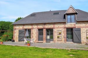 a brick house with black doors and a lawn at Charmante Maison à Fort-Moville avec Terrasse Privée in Fort-Moville +15 photos
