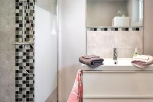 a bathroom with a sink and a mirror at Charmante Maison à Fort-Moville avec Terrasse Privée in Fort-Moville