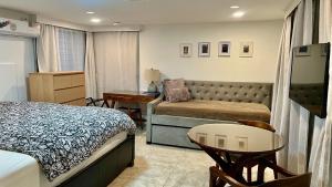 a bedroom with a bed and a couch and a table at 3 doors down to New Orleans , Excellent location! in Arabi