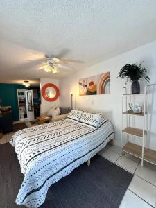 a bedroom with a large bed with a ceiling fan at Oesta Palma's Guest House with BBQ & Beach Gear Near Downtown WBP in West Palm Beach