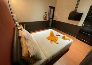 a bedroom with a bed with yellow robes on it at Kavy Boutique Hotel @ KBH in Brinchang