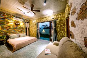 a bedroom with a bed and a couch at La Rocca An Bang Beach in An Bàn (2)