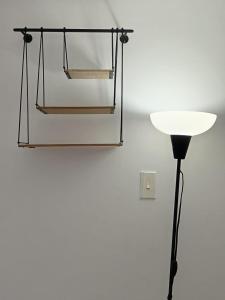 a glass lamp and a black pole next to a wall at Comfy apartment in historic center in Cartagena de Indias