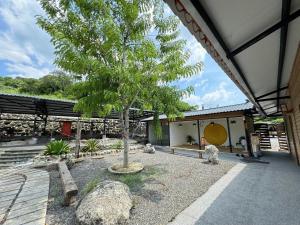 a tree in front of a building with rocks at 虎山渡假村 in Baihe +20 photos