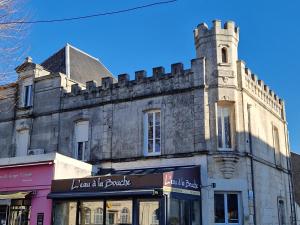 an old building with a clock tower on a street at Appartement lumineux 2 ch, proche plage & commerces - FR-1-706-31 in Châtelaillon-Plage