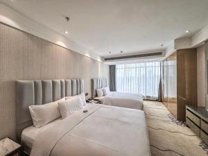 Postel nebo postele na pokoji v ubytování Suning Universal Hotel ALL-SUITES