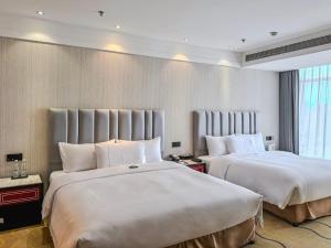 Postel nebo postele na pokoji v ubytování Suning Universal Hotel ALL-SUITES