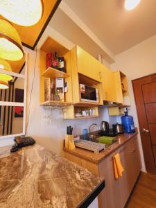 a kitchen with wooden cabinets and a counter top at MesaCondo Studio with Balcony in Davao City