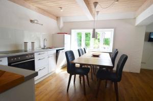- une cuisine avec une table à manger et des chaises dans l'établissement Wohnung-1, à Nebel