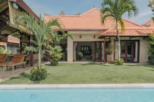 een huis met een tuin met een zwembad bij Tropical Villa Asmara - 400sqm Garden Oasis with large Pool and Scenic Views in Uluwatu