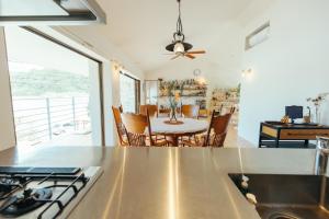 een keuken en een woonkamer met een tafel en een eetkamer bij 1日2組限定オーシャンビューのお宿-MANANI House- in Ōura