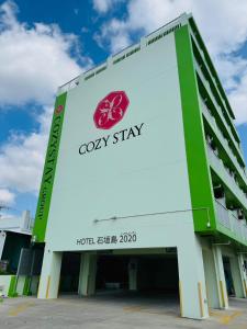 a building with a sign that reads cosy stay at HOTEL Ishigakijima 2020 in Ishigaki Island