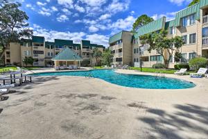 a swimming pool in front of a building at Beach and Pool Access Tranquil Hilton Head Getaway in Hilton Head Island