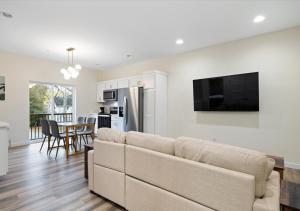 Una sala de estar con un sofá y una cocina. en Fall at Golden Goose including King Bed, Parking, Security and Laundry, en Evansville