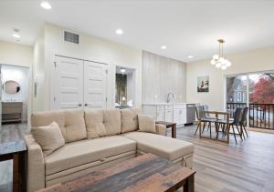 Una sala de estar con un sofá y una cocina. en Fall at Golden Goose including King Bed, Parking, Security and Laundry, en Evansville