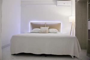 a white bed with white sheets and pillows on it at Appartement Ora in Baie Nettle